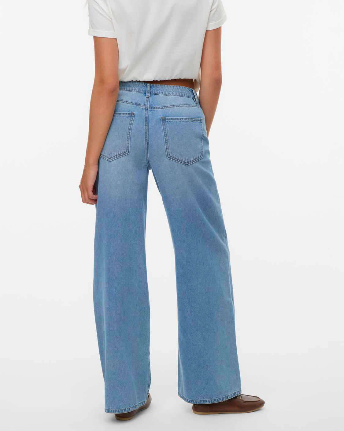 Person wearing light blue jeans and a white shirt on a white background